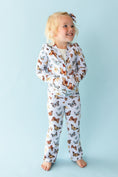 Load image into Gallery viewer, A young child smiles barefoot in a matching Jammie Session Butterfly Kisses Kids' Jacket (runs small, please size up) with butterfly print, coordinating pants, and headband against a light blue background.