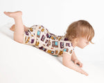 A toddler dressed in the Jammie Session 90's Retro Short Pajama Set is crawling down a white slope against a plain background.