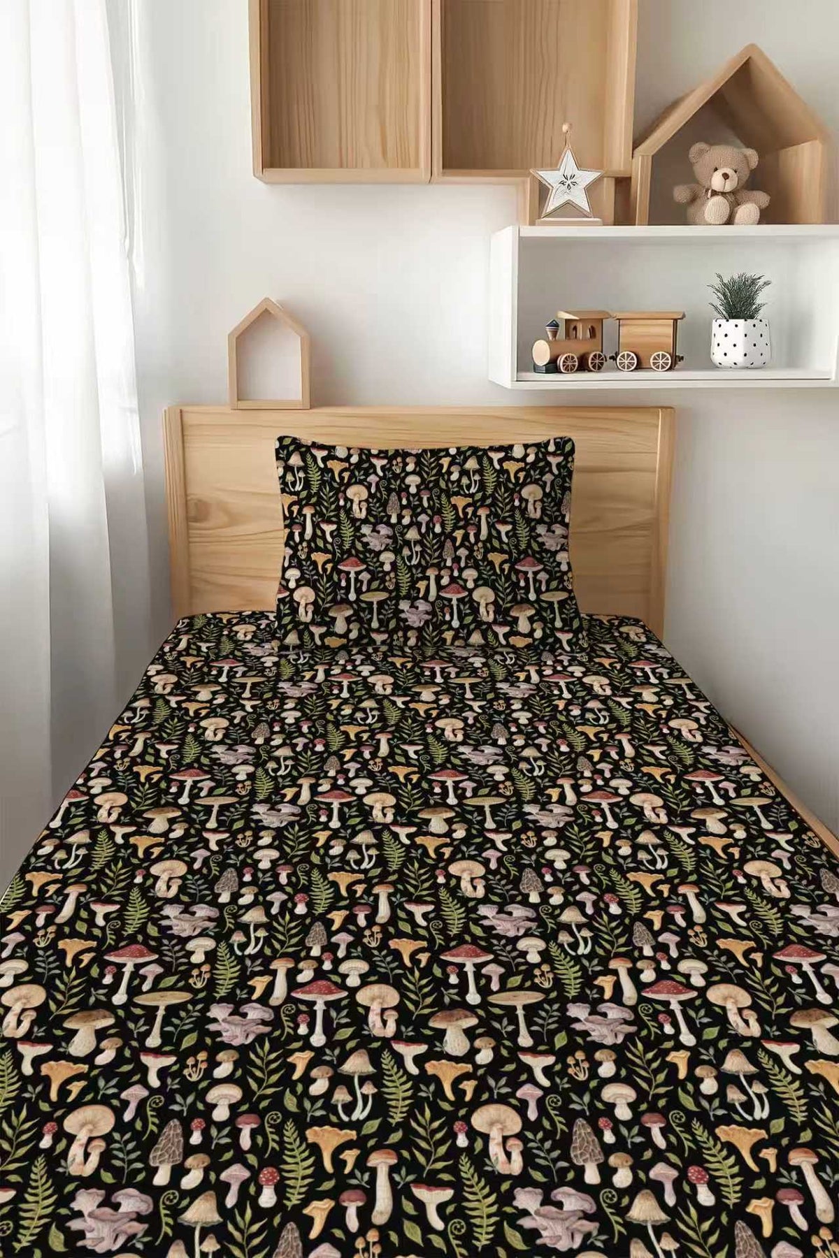 A neatly made bed features the Jammie Session Mystic Mushrooms Twin Fitted Sheet and Pillowcase Set, with a vibrant mushroom and foliage pattern; wooden shelves, decor, and a toy train are in the background.