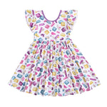 The Block Party (Purple) Short Sleeve Big Kid Twirl Dress by Big Dreams Little Jammies is a white, hypoallergenic dress with ruffled sleeves and a colorful cartoon soap bar print in pink, yellow, blue, and purple.