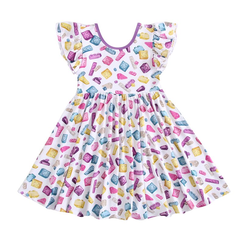 The Block Party (Purple) Short Sleeve Big Kid Twirl Dress by Big Dreams Little Jammies is a white, hypoallergenic dress with ruffled sleeves and a colorful cartoon soap bar print in pink, yellow, blue, and purple.