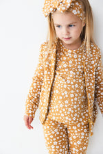 A young girl, styled in the Jammie Session Honey Blooms Kids' Jacket (runs small, please size up), wears a matching mustard-yellow floral outfit and headband, standing against a plain white background.